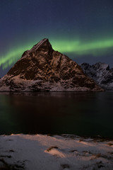 Fototapeta na wymiar Northern light display over Reinefjorden (Lofoten) in winter