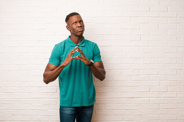 young african american black man scheming and conspiring, thinking devious tricks and cheats,...
