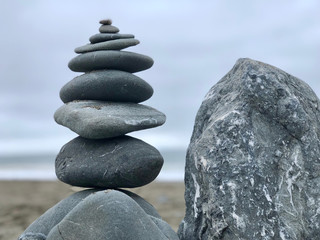 Pebbles one above other on sand near the sea.