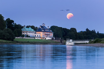 Partial lunar eclipse during moonrise over Pillnitz castle in Dresden, Germany