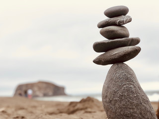 Some pebbles one above other on sand.