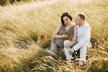 Pragnant woman. Family in a field. Man in a white shirt