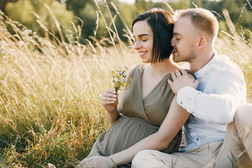 Pragnant woman. Family in a field. Man in a white shirt