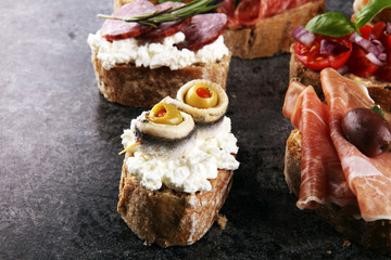 Appetizers table with italian antipasti snacks and wine in glasses. Brushetta or authentic traditional spanish tapas set, cheese variety