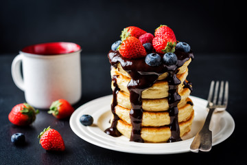pancakes with chocolate glaze, strawberries, blueberries and raspberries