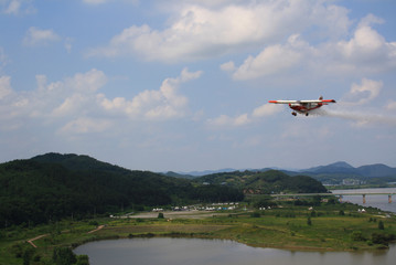 Fototapeta na wymiar Airplane flying over the lake