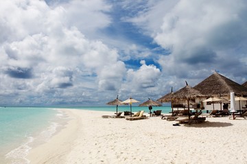 Sun umbrellas and chairs in a white sand beach of Maldives 