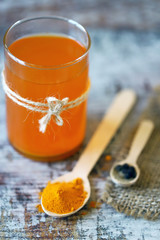 Warm water with turmeric in a glass. Turmeric and black pepper. Selective focus. Macro. Golden water.