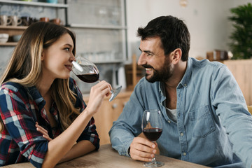 Young couple in love enjoying in conversation while drinking red wine