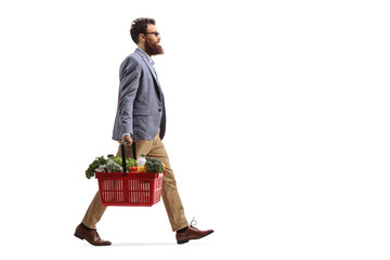 Bearded man walking and carrying a shopping basket with food