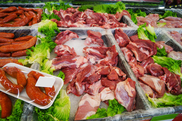 Meat department shelves with typical raw meat. Close-up of meat in display at supermarket