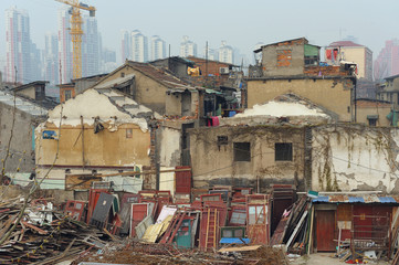 Ruined old buildings in Shanghai with people still living there. Modern city in background