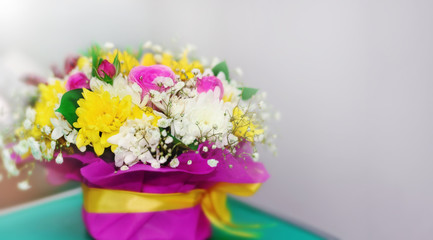 Bouquet of bright flowers in a vase for the holiday. Blurred background.