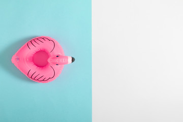 Summer beach composition. pink inflatable mini flamingo on pastel blue background, pool float...