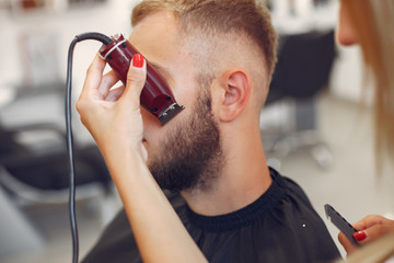 Man with a beard. Hairdresser with a client. Woman shaving a man's beard