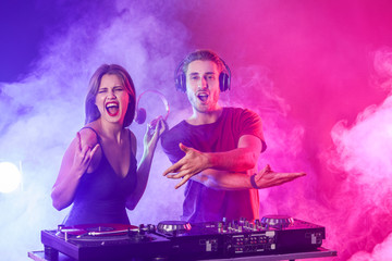 Young djs playing music in nightclub