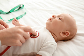 Obraz na płótnie Canvas Pediatrician examining cute baby in clinic, closeup