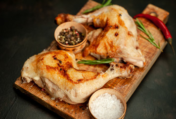 Two fried chicken legs on a stone background with spices, ready to eat