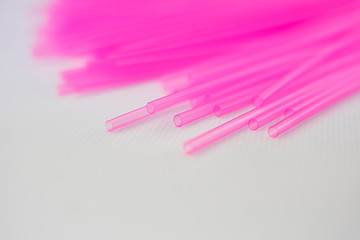 Pink plastic straws for use with drinks such as soft drinks, juices and alcohol