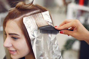 Hairdresser colored hair her client. Woman in a hair salon