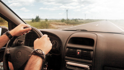 Hands driving car wheel