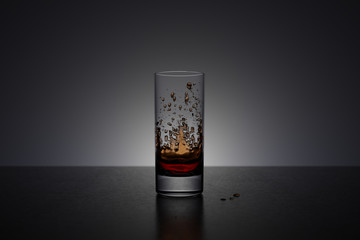 Glass with splash of cola on dark background