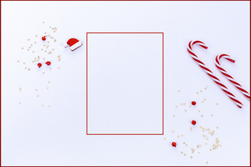Modern Christmas background with red frame, candy canes, confetti and hat in red and white