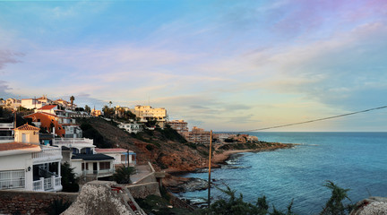 View by the sea in Torrevieja, Alicante, Spain. Sunset with a horizon of houses and the ocean.