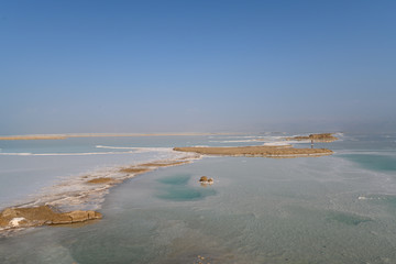 View of Dead Sea coastline with it's beautiful sand and salt in the middle of the water. Aerial shot captured from the shore