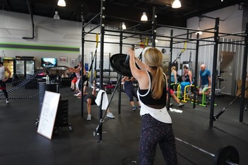 woman exercising in crossfit gym with t bar row press. 