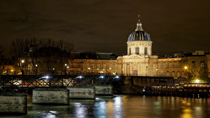 Fototapeta premium Paris, France - November 17, 2019: The Pont des Arts or Passerelle des Arts is a pedestrian bridge in Paris which crosses the Institut de France. With Institut de France in background