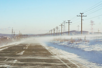 Naklejka na ściany i meble winter track, snowstorm and snow, cyclone, dangerous road, wind, middle lane of Russia, asphalt, speed 
