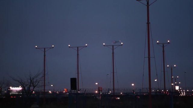 Jet Landing at Chopin, Warsaw. Airport at Dusk. Poland. Flying Boeing lands at the airport, night landing. Airplane flying over head at night, landing or taking off.