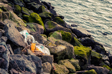 plastic bag on rocks next to river