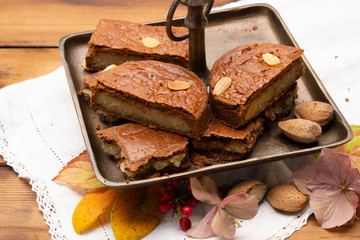 Fresh baked Dutch filled spicy cookies with almonds in autumn colors on dark wooden background