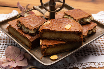 Fresh baked Dutch filled spicy cookies with almonds in autumn colors on dark wooden background