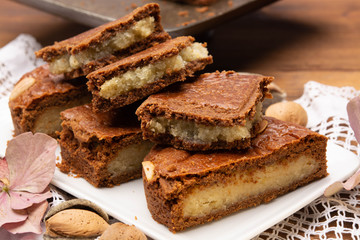 Fresh baked Dutch filled spicy cookies with almonds in autumn colors on dark wooden background