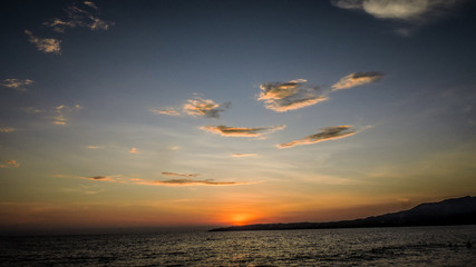 SUNSET WITH CLOUDS AND MOUNTAINS