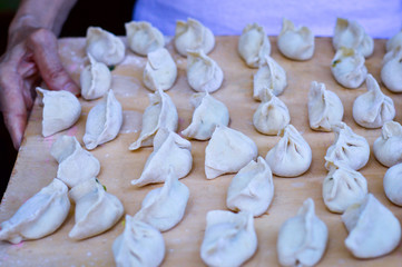 Fototapeta na wymiar Hands Holding Board with Chinese Dumplings.