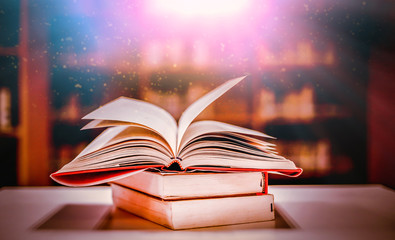 Stack of books in the library and blur bookshelf background