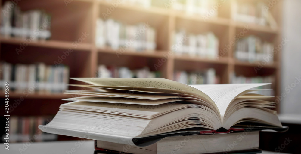 Poster stack of books in the library and blur bookshelf background