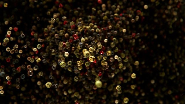 Super slow motion of flying whole coloured pepper spice. Filmed on high speed camera, 1000 fps