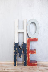 The word "home" from wooden letters on grey background