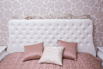 White beautiful bedhead with pink pillows