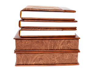 Stack of elegant brown books on white background. Wedding photobook. Wedding photo album. White background