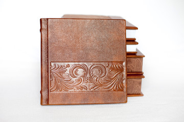 Stack of elegant brown books on white background. Wedding photobook. Wedding photo album. White background