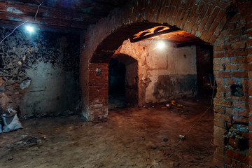 Fototapeta na wymiar Abandoned empty old dark underground vaulted cellar