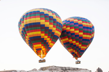 Many colorful hot air balloons flight above mountains - panorama of Cappadocia at sunrise. Wide landscape of Goreme valley in Cappadocia - billboard background for your travel concept in Turkey.