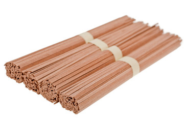 Dried raw japanese soba noodle sticks isolated on white background. 