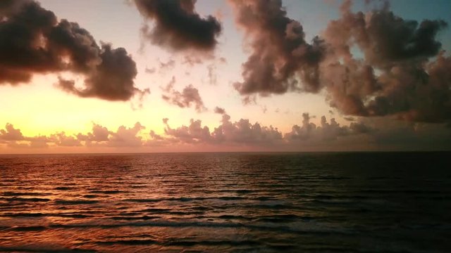 A vivid aerial view taken by a drone heading off of a Padre Island beach and over the waves at sunrise
